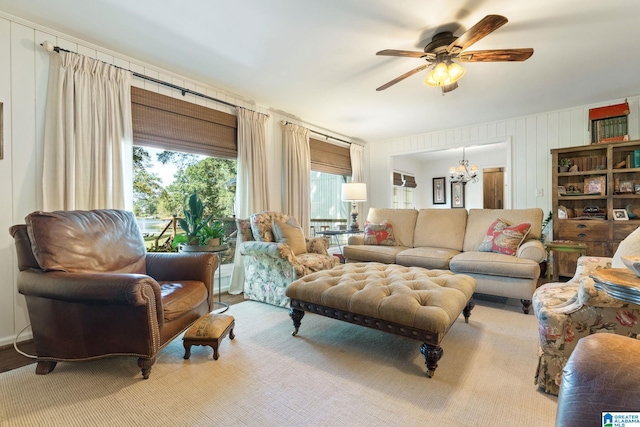 living room featuring ceiling fan with notable chandelier