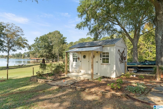 view of outbuilding with a water view and a yard