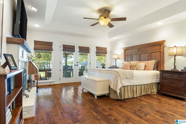 bedroom with access to outside, dark hardwood / wood-style flooring, multiple windows, and a raised ceiling