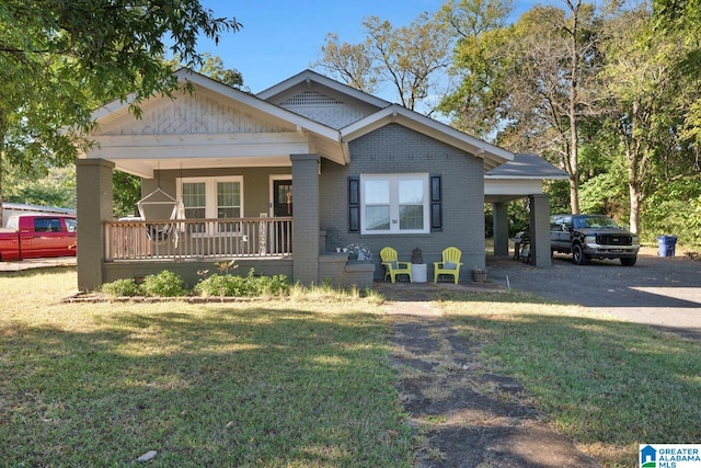 view of front of home with a front yard, a carport, and a porch