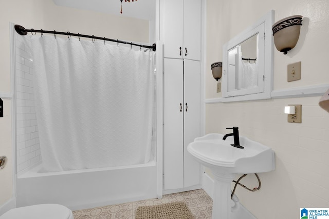 bathroom featuring shower / bath combo with shower curtain, toilet, tile walls, and tile patterned flooring