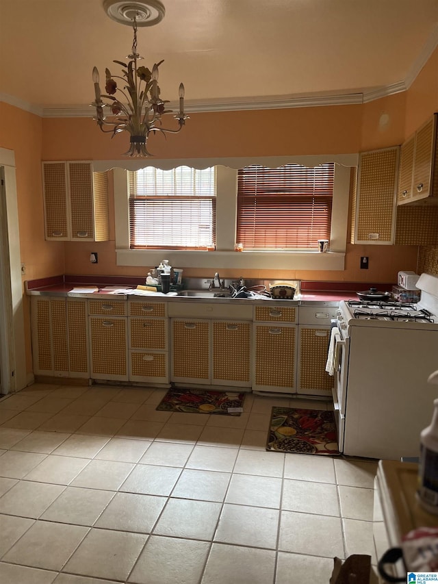 1244 15th St, Birmingham, AL 35211 - kitchen featuring gas range gas stove, light tile patterned flooring, crown molding, a sink, and a chandelier
