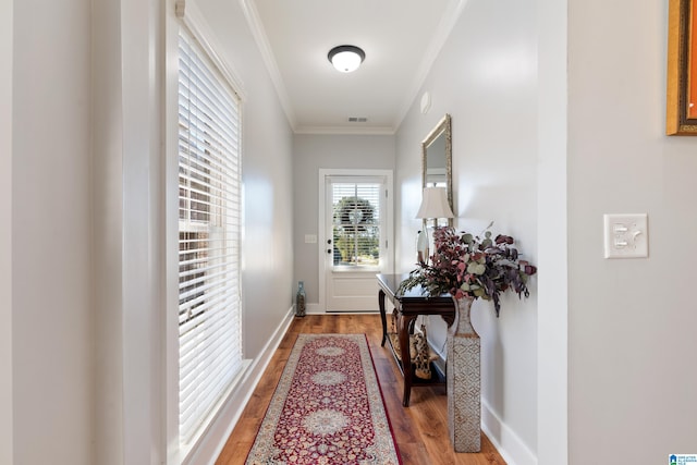 doorway with crown molding and wood-type flooring