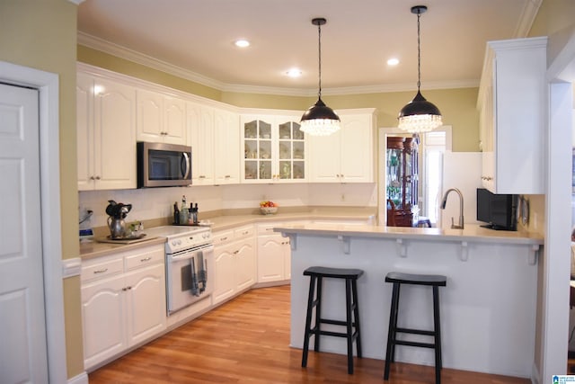 kitchen with kitchen peninsula, electric range, white cabinetry, a chandelier, and light hardwood / wood-style flooring