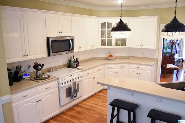 kitchen featuring light hardwood / wood-style flooring, white cabinetry, white electric range oven, and pendant lighting