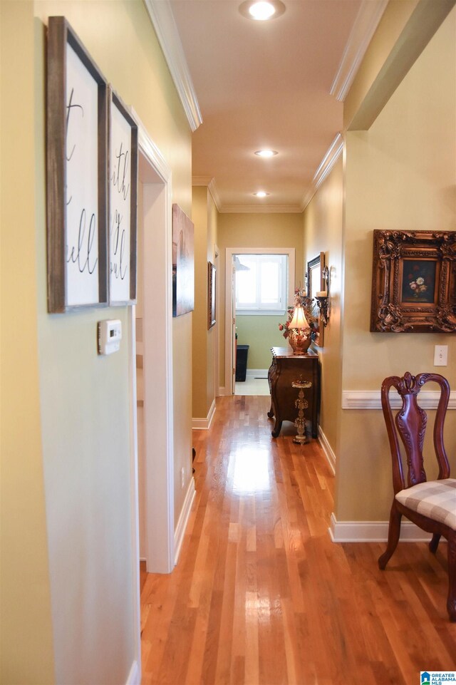 hall featuring crown molding and light hardwood / wood-style flooring