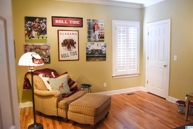 sitting room with crown molding and hardwood / wood-style flooring