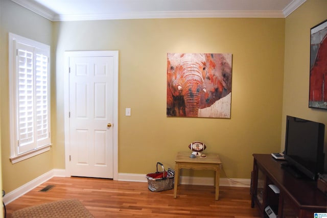 sitting room with crown molding and light hardwood / wood-style floors