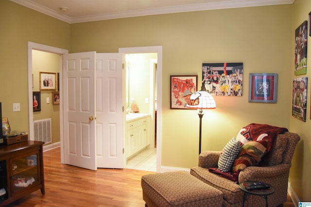 sitting room featuring crown molding and light wood-type flooring