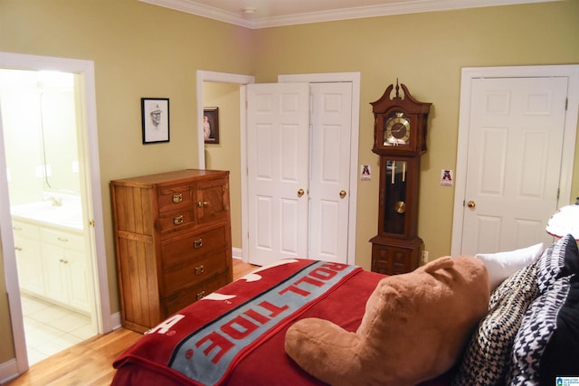 bedroom with connected bathroom, crown molding, and light hardwood / wood-style flooring