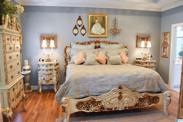 bedroom with hardwood / wood-style floors and crown molding