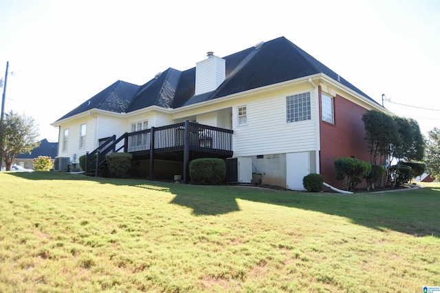 rear view of property featuring a wooden deck, central AC, and a yard