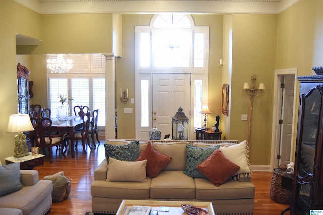 living room featuring a healthy amount of sunlight, wood-type flooring, and a chandelier