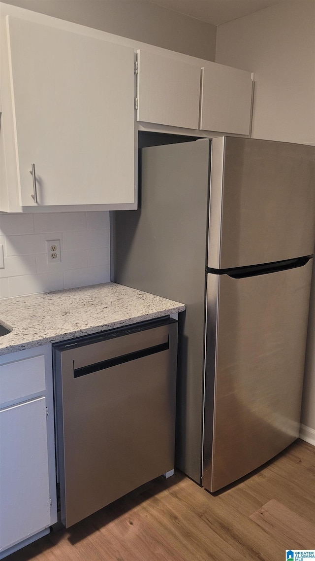 211 Morning Sun Dr Unit 211, Birmingham, AL 35242 - kitchen featuring light wood-style floors, decorative backsplash, stainless steel appliances, light stone countertops, and white cabinetry