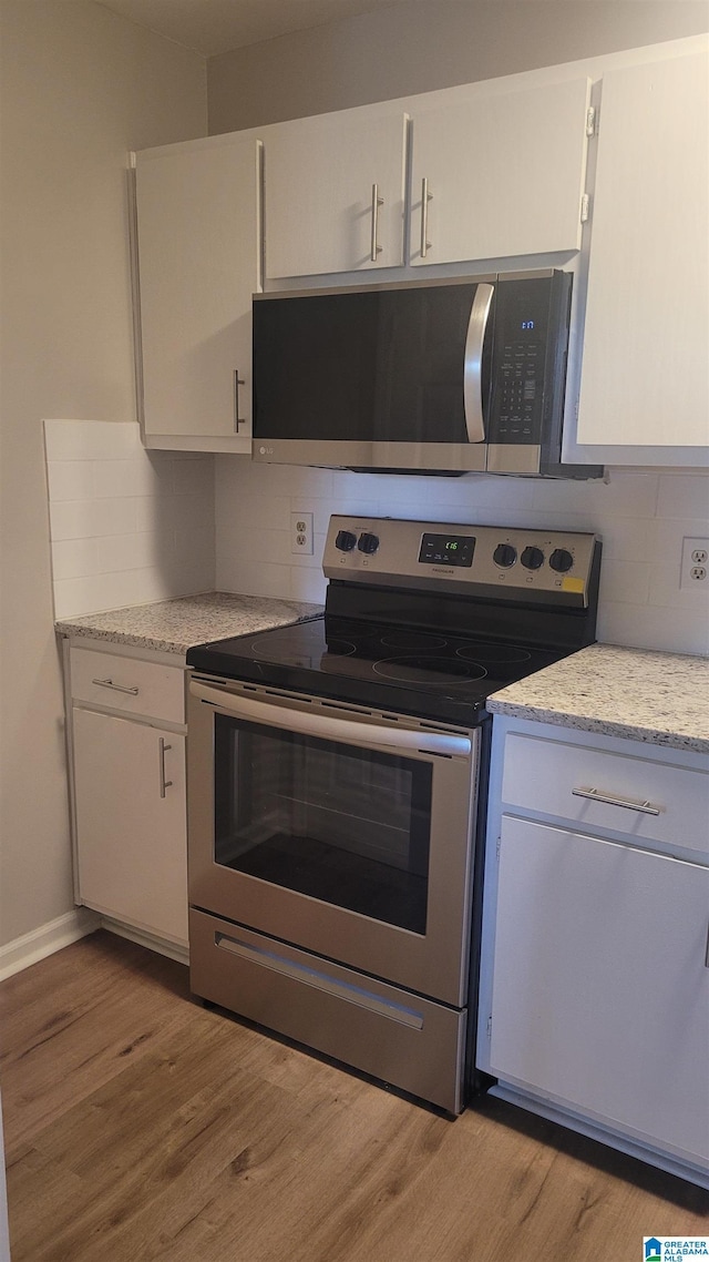 211 Morning Sun Dr Unit 211, Birmingham, AL 35242 - kitchen featuring stainless steel appliances, light wood-type flooring, tasteful backsplash, white cabinetry, and light stone counters