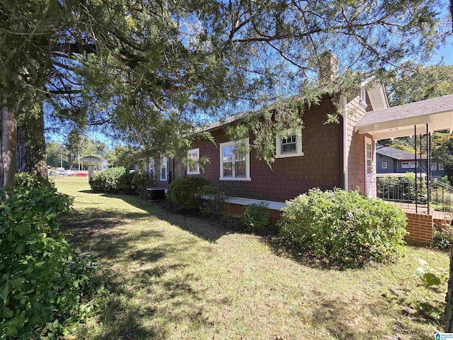 view of side of home featuring a yard and a chimney