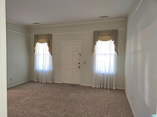 foyer featuring crown molding, carpet, and baseboards