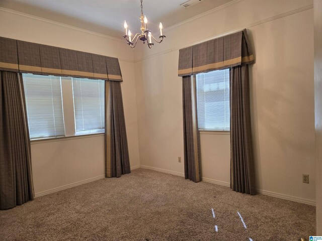 empty room featuring a chandelier, crown molding, carpet, and baseboards