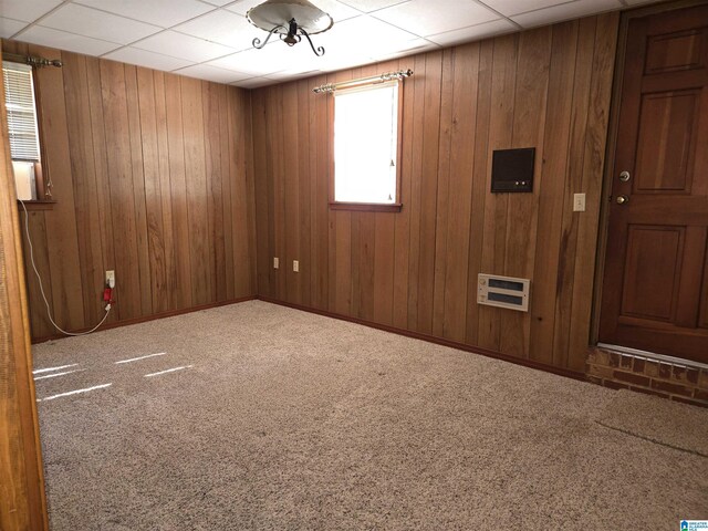 empty room with carpet floors and wood walls