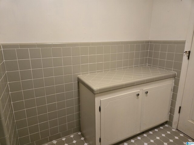 bathroom with wainscoting and tile walls