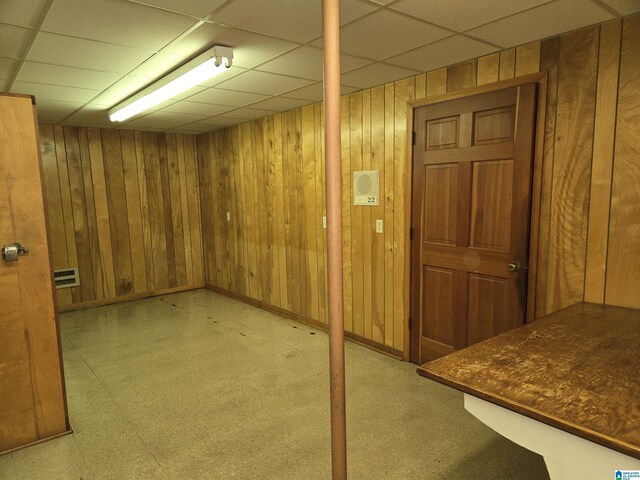 finished below grade area with wood walls and a paneled ceiling