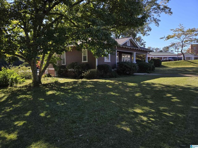 view of property hidden behind natural elements featuring a front yard