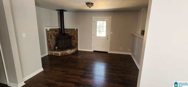 entryway with a wood stove and dark wood-type flooring