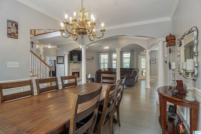 dining room with crown molding, hardwood / wood-style flooring, and ornate columns