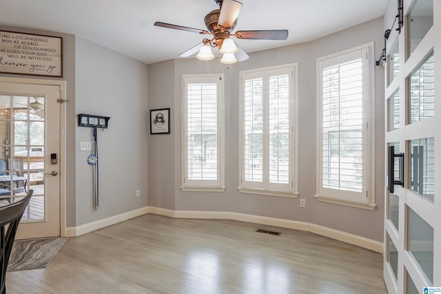 foyer entrance with ceiling fan, light wood-type flooring, and a wealth of natural light