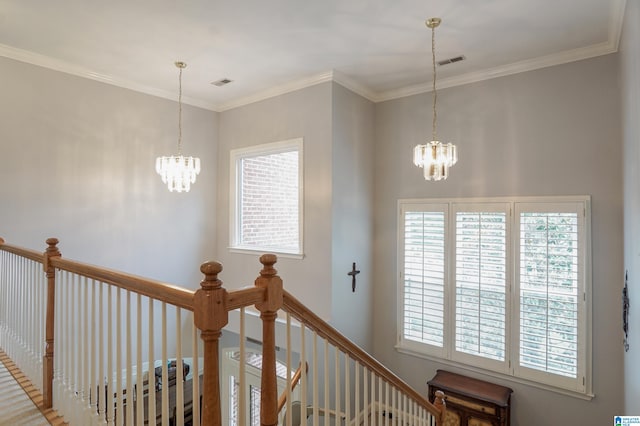 hallway with ornamental molding and a notable chandelier