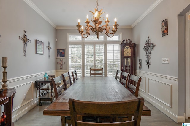 dining area featuring an inviting chandelier, ornamental molding, and hardwood / wood-style flooring