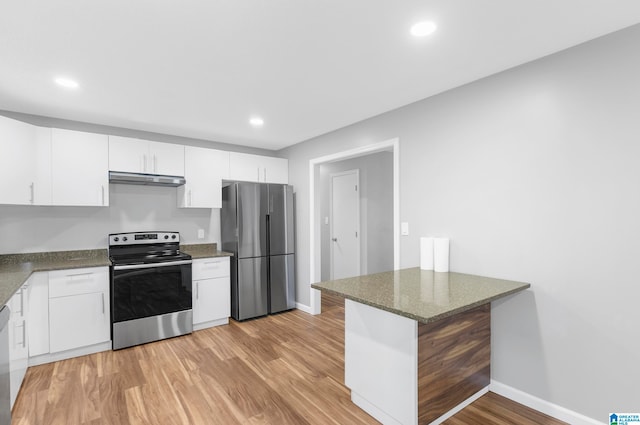 kitchen with kitchen peninsula, appliances with stainless steel finishes, white cabinetry, light wood-type flooring, and dark stone counters