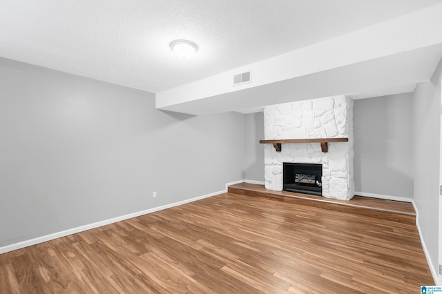 unfurnished living room featuring a textured ceiling, a fireplace, and hardwood / wood-style flooring