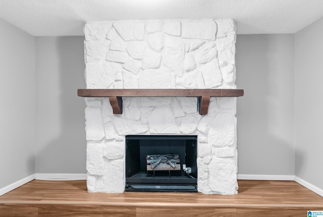 details featuring a textured ceiling, wood-type flooring, and a fireplace