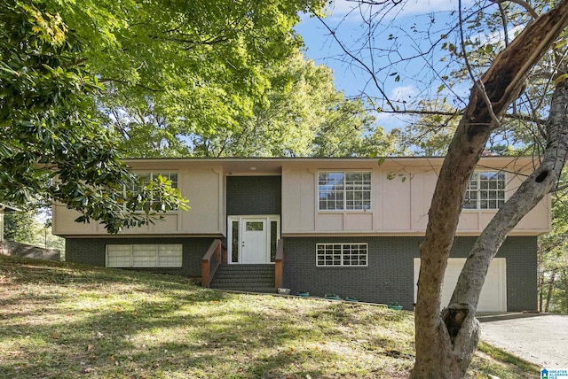 split foyer home featuring a front yard and a garage