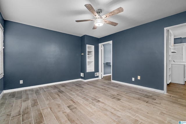 empty room featuring light hardwood / wood-style flooring, built in shelves, and ceiling fan