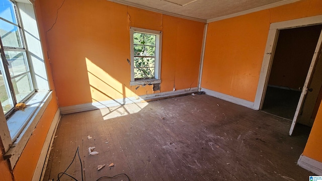 empty room featuring ornamental molding and dark hardwood / wood-style flooring