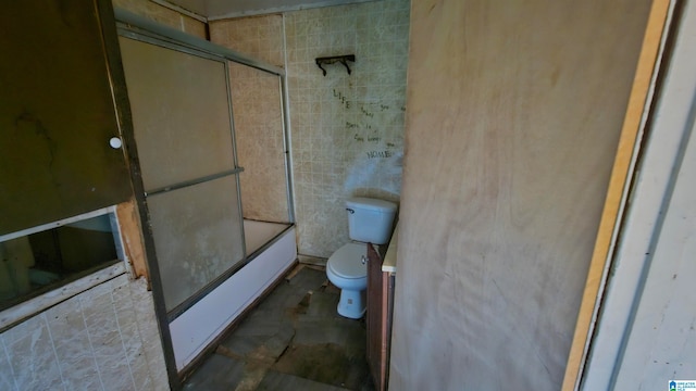 bathroom featuring enclosed tub / shower combo and toilet