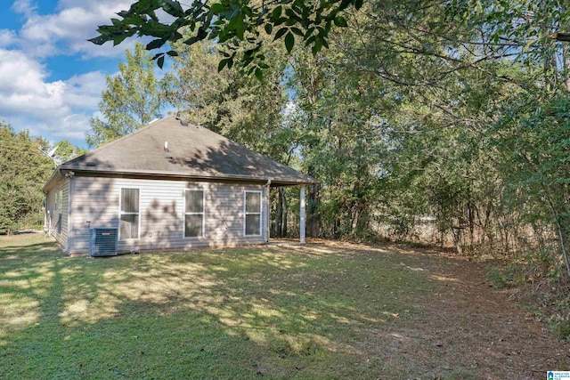 rear view of property with a yard and central AC unit