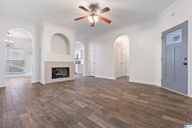 unfurnished living room with a tiled fireplace, crown molding, and dark hardwood / wood-style flooring