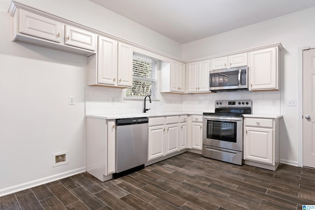 kitchen with white cabinetry, backsplash, stainless steel appliances, and dark hardwood / wood-style flooring