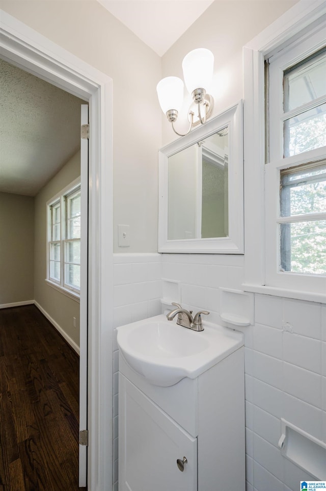 bathroom with vanity, hardwood / wood-style floors, and tile walls