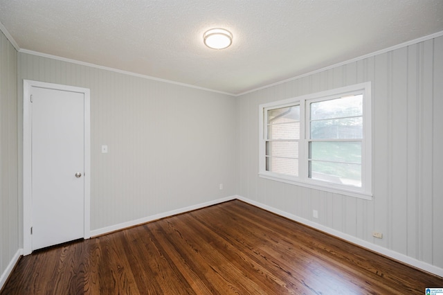 unfurnished room with ornamental molding, a textured ceiling, and dark hardwood / wood-style flooring