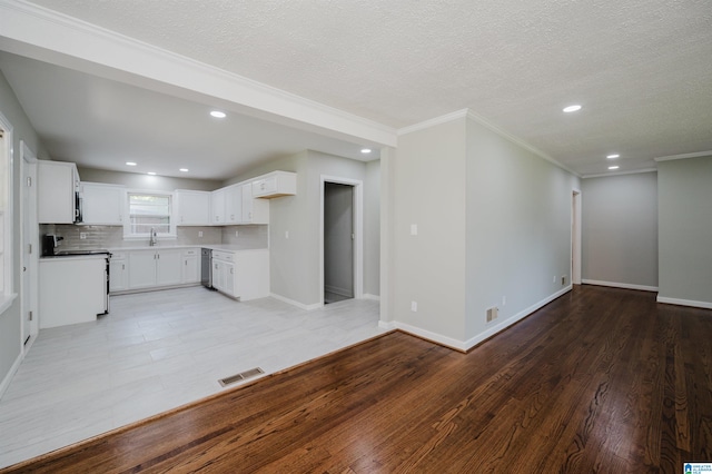 kitchen featuring white electric range oven, a textured ceiling, white cabinetry, and hardwood / wood-style flooring