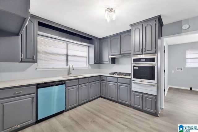 kitchen featuring stainless steel appliances, sink, light wood-type flooring, and gray cabinets