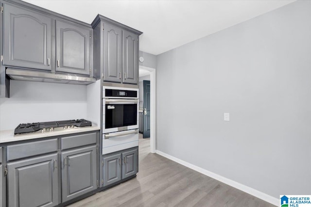 kitchen featuring gray cabinetry, appliances with stainless steel finishes, and light hardwood / wood-style flooring