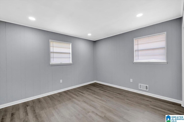 empty room featuring wood walls and hardwood / wood-style flooring