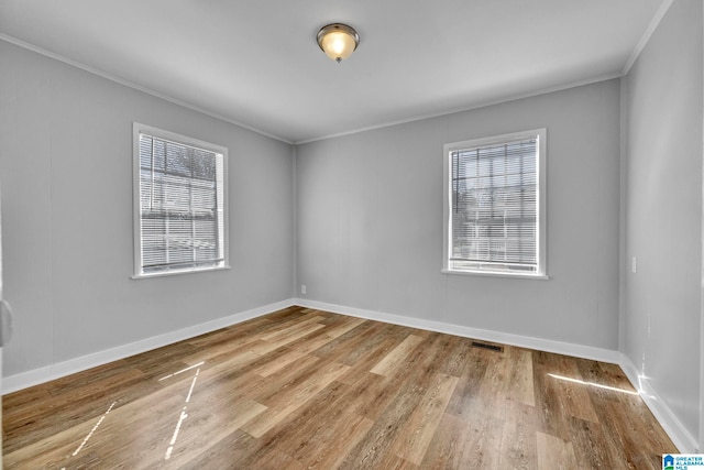 spare room featuring ornamental molding and hardwood / wood-style floors