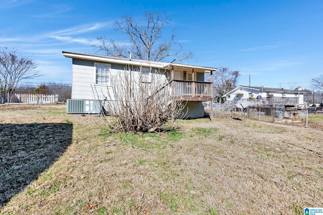 rear view of house with a yard, cooling unit, and a wooden deck