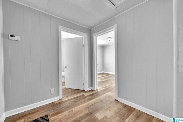 interior space with light hardwood / wood-style flooring and wooden walls